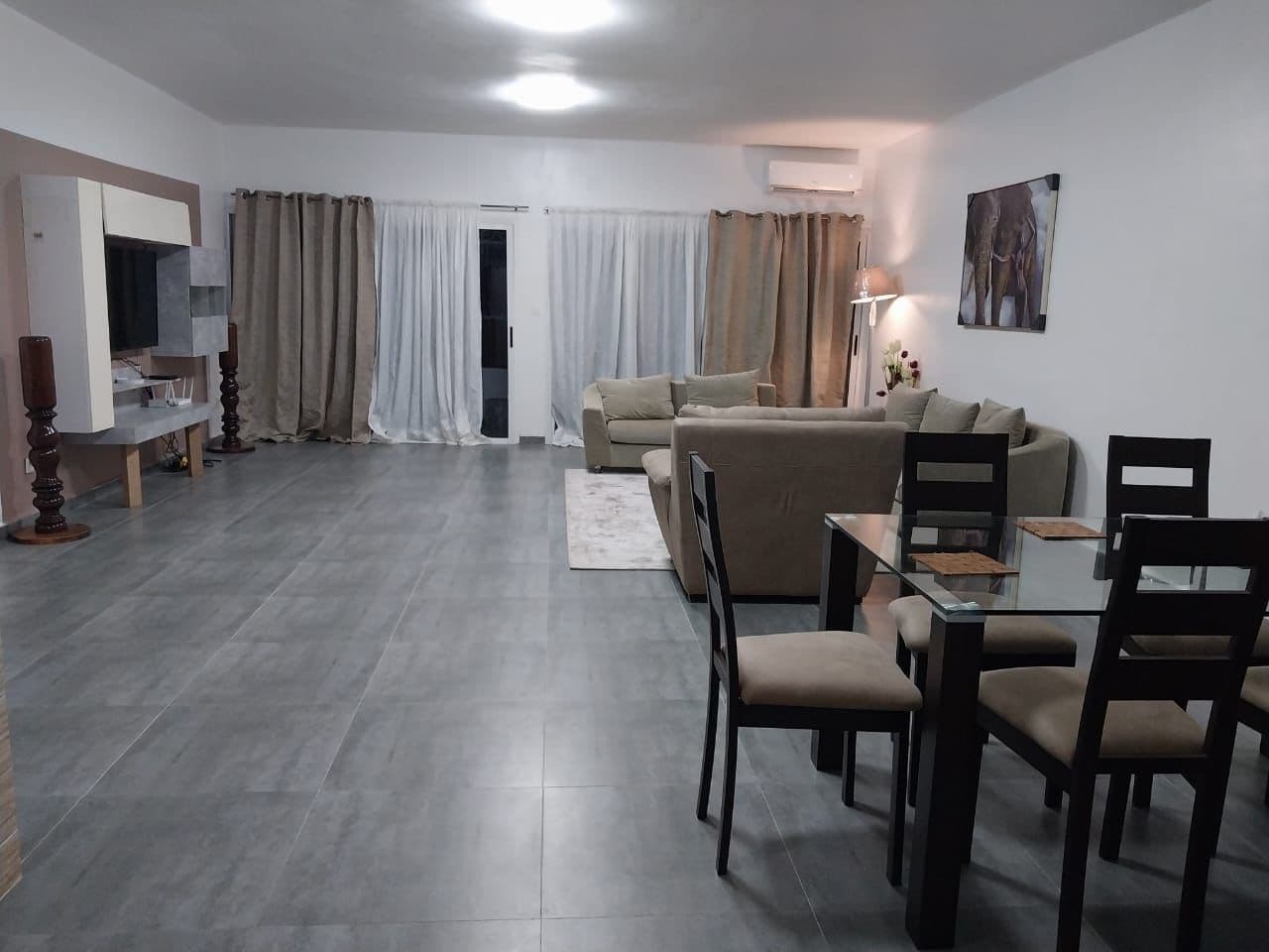 Grand séjour de la Résidence Bambou avec canapés et salle à manger