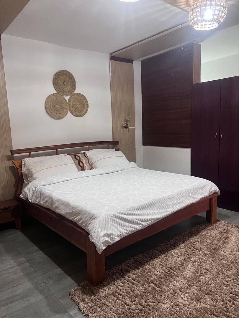 Chambre au lit en bois massif et déco rotin