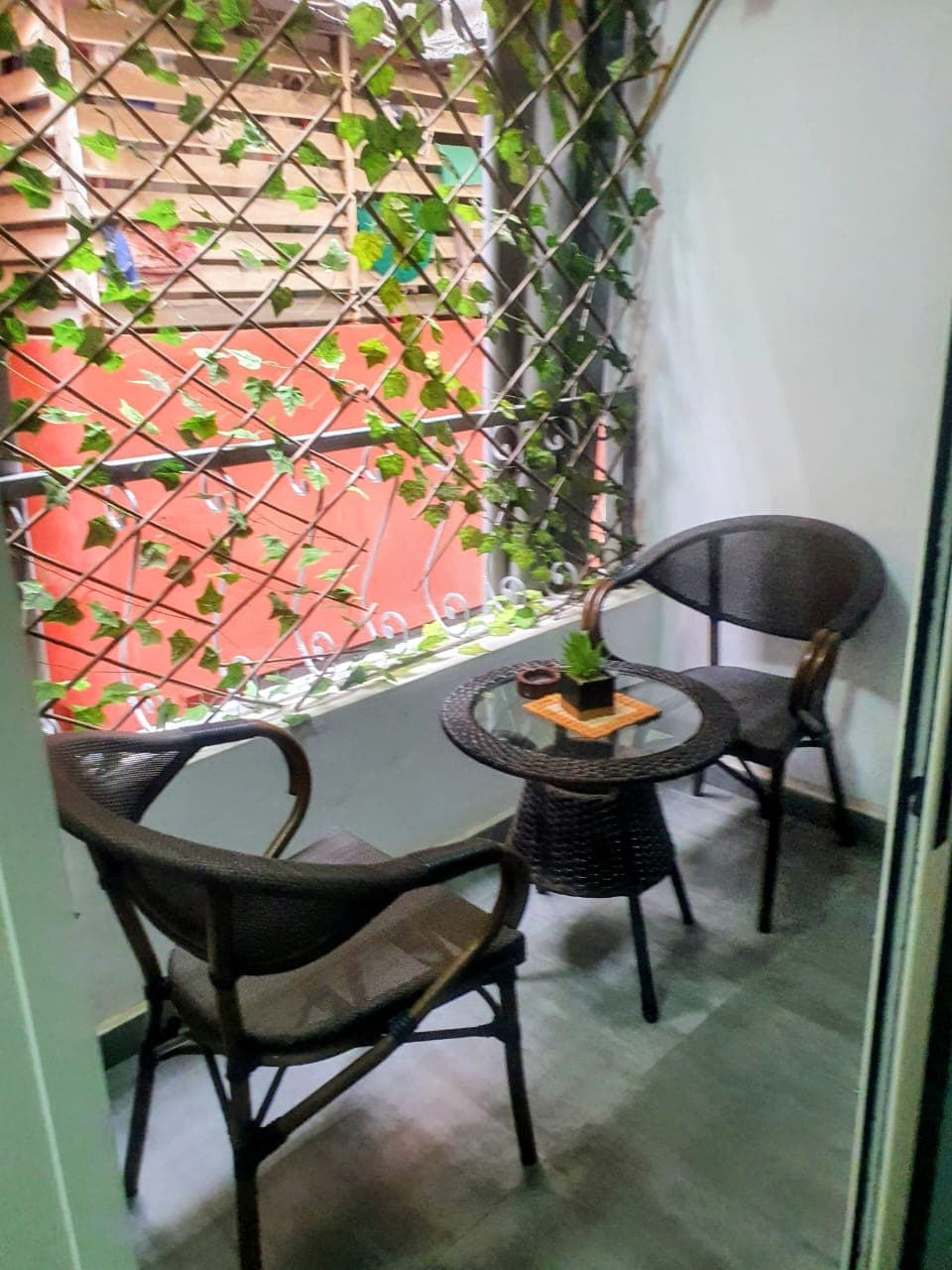 Patio avec fauteuils en rotin et mur végétal