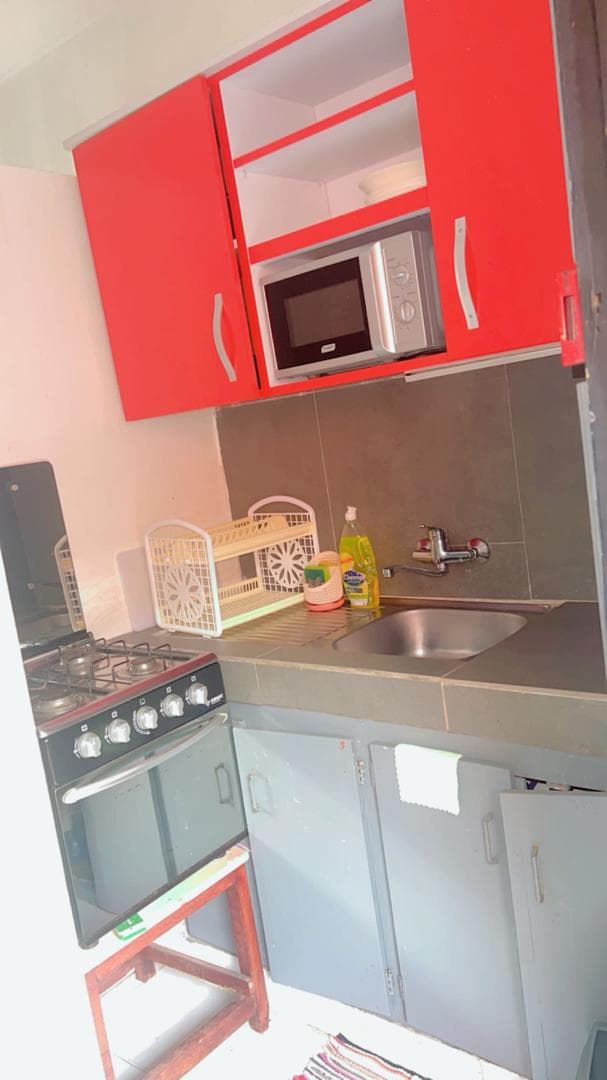 Kitchenette aux placards rouge coquelicot avec micro-ondes