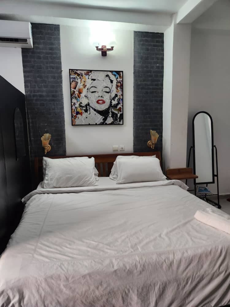 Lit du Studio Icône sous le portrait de Marilyn, mur de briques sombres