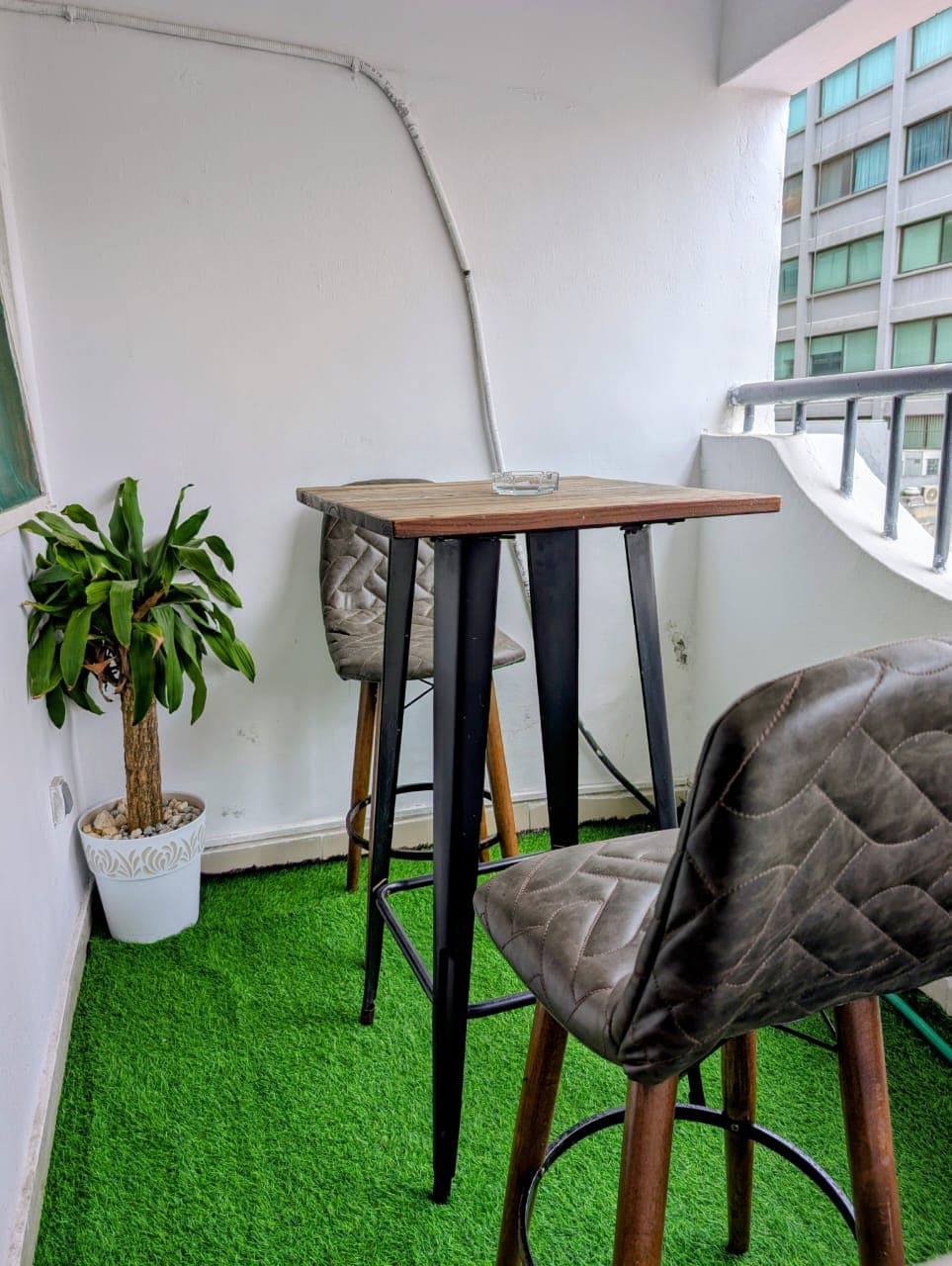 Balcon avec table haute et plante verte