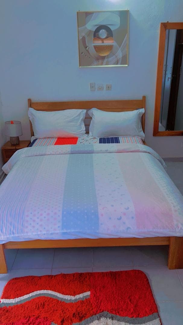 Coin nuit du Studio Coquelicot, grand lit et tapis rouge